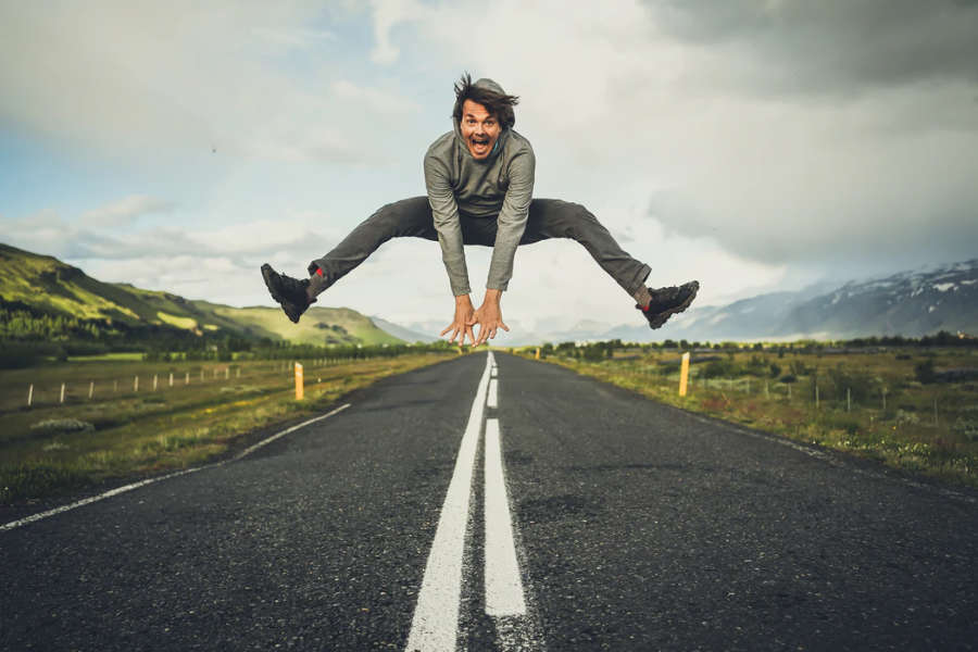 man jumping for joy on road