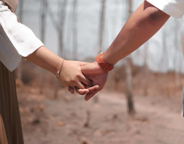 couple holding hands while on a walk