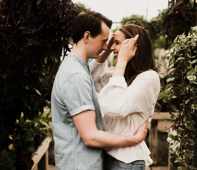 happy couple embracing amongst some trees